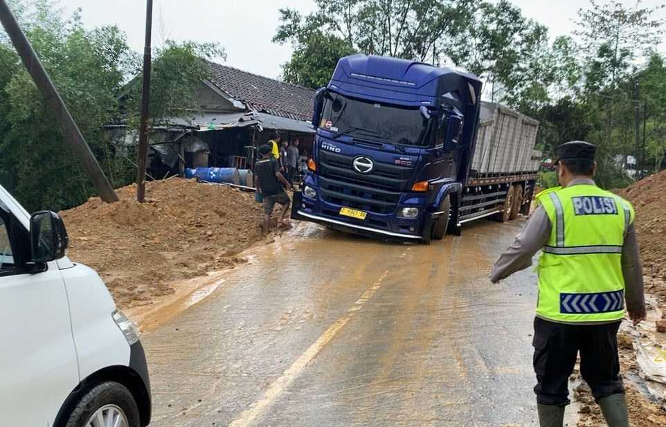 Jalan Licin Sebabkan Truk Tergelincir, Polsek Cikajang Lakukan Evakuasi dan Atur Lalin